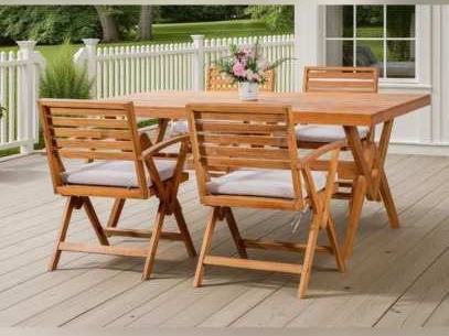 Teak dining table and crossed-leg armchairs on a timber deck