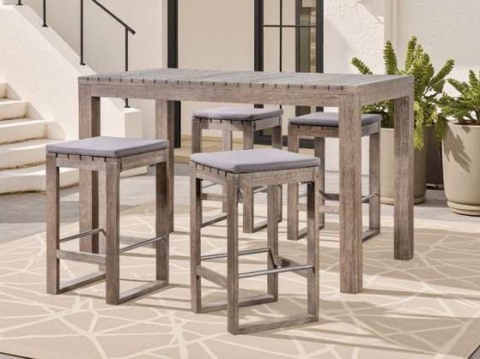 Bàn bar dài và bốn ghế đẩu đệm xám trên thảm sân hiên