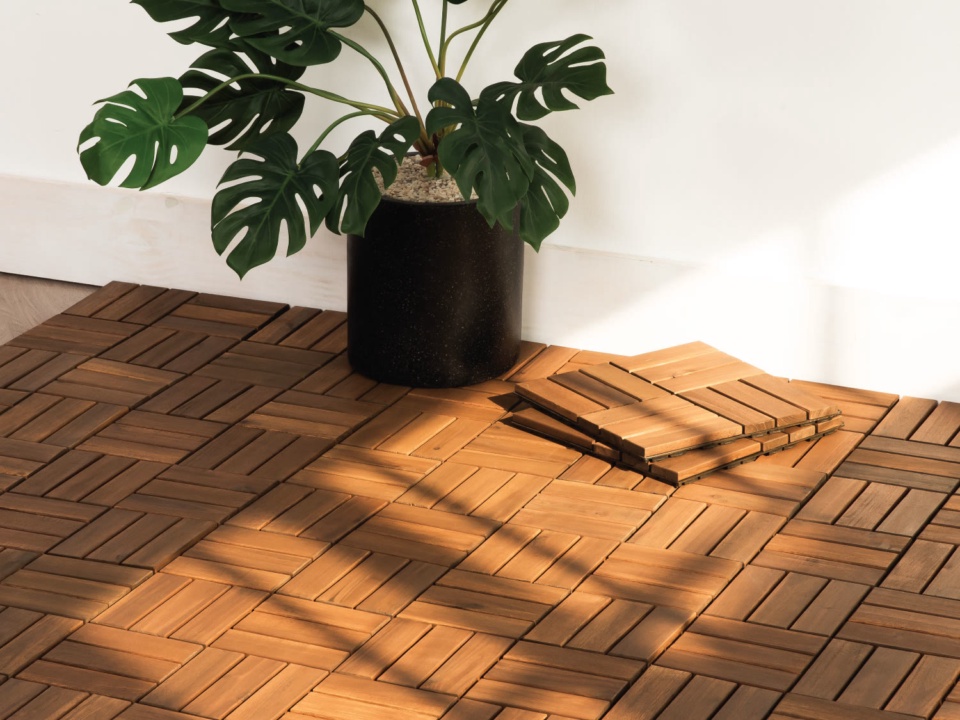 Ván sàn gỗ keo lắp ghép đã lát trong góc phòng, cạnh chậu cây