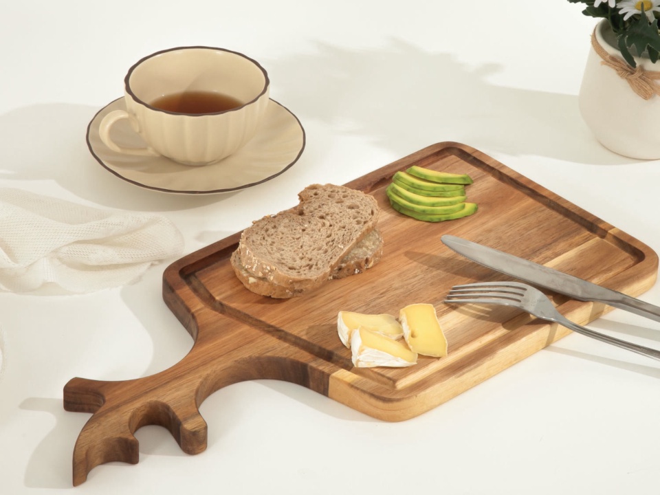 Thớt gỗ có tay cầm hình sừng hươu, bày bánh mì và phô mai