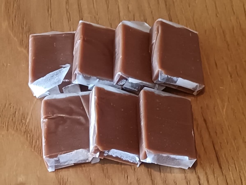 Kẹo dừa socola gói giấy xếp trên mặt gỗ