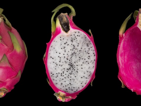 Whole, halved white flesh and empty shell dragon fruit on black