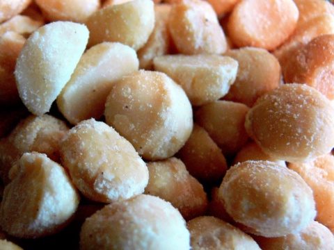 Close-up of lightly roasted pale yellow and orange macadamia kernels