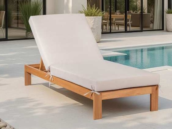 Wooden sun lounger with tied cream cushions near a pool