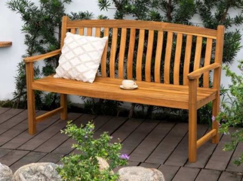Honey-coloured wooden bench with armrests on a garden deck