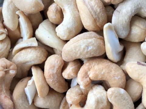 Close-up of cream coloured whole and split cashew kernels