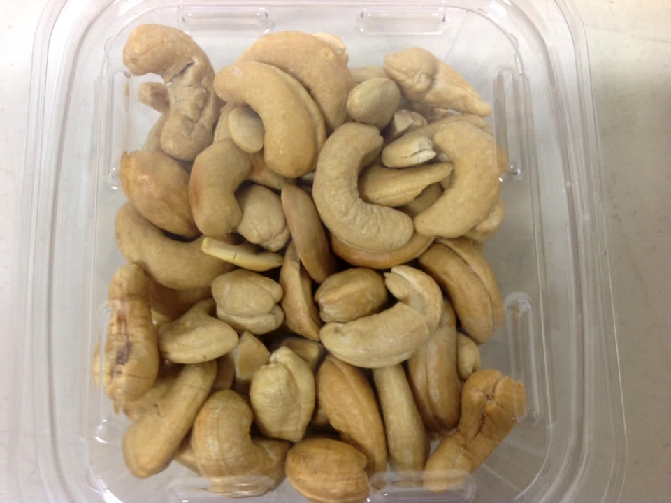 Cashew kernels in a clear plastic tub without a label