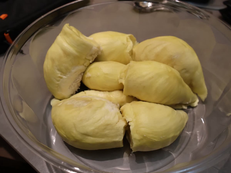 Yellow durian pulp segments arranged on a clear round plate