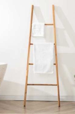 Wooden towel ladder against a wall with two white towels, full view