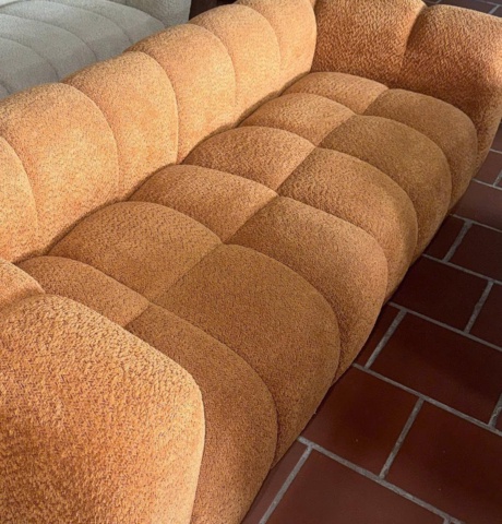 Sofa dài bọc vải xù màu cam, nhìn gần các múi nổi