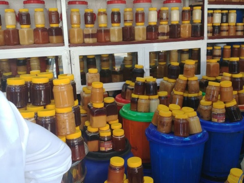 Kệ và xô chai hũ mật ong nắp vàng bày bán