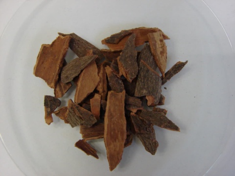 Reddish-brown cassia bark fragments on a glass dish