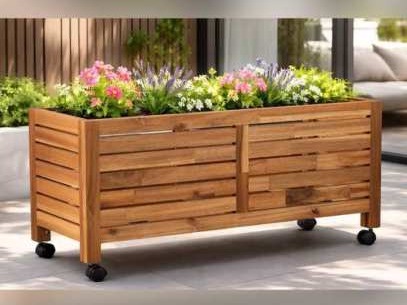 Long wooden planter of flowers on small wheels on a patio