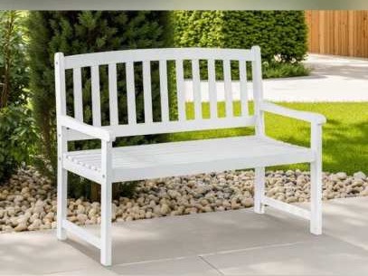 White painted wooden bench beside pebbles and a lawn