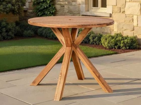 Round acacia table with star-shaped crossing legs on paving beside a lawn