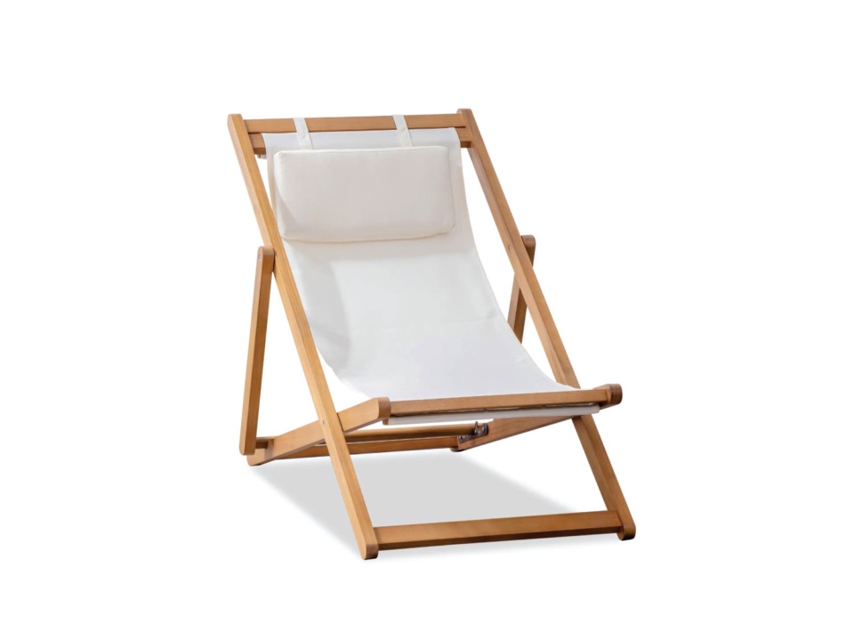 Folding wooden lounge chair with cream canvas seat and headrest cushion, white background