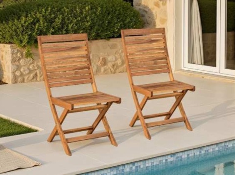 Two slatted wooden folding chairs on a terrace beside a pool