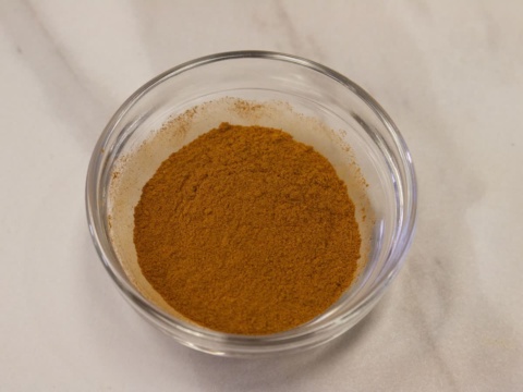 Golden brown cinnamon powder in a small glass bowl