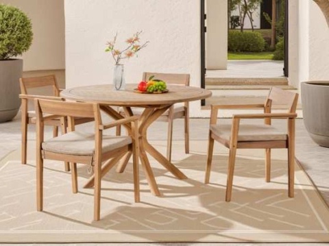 Round acacia dining table and four chairs with beige cushions