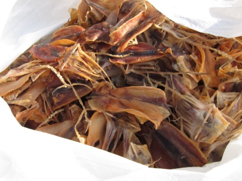 Whole dried squid heaped in a white bag