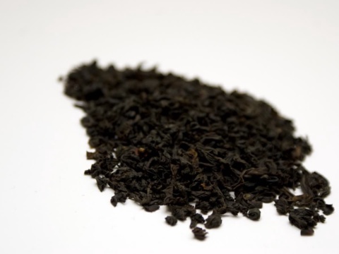 A small pile of finely cut dried black tea on white