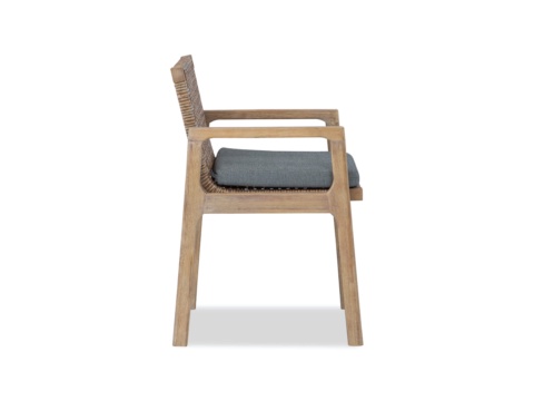 Side view of a dining armchair with woven back and grey cushion