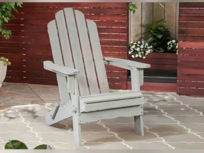 Pale grey painted Adirondack chair on a patterned patio