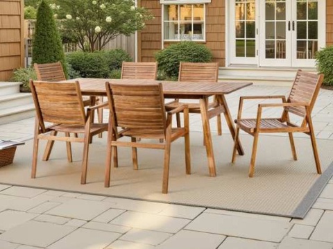 Acacia dining table and slat-back armchairs on a paved patio