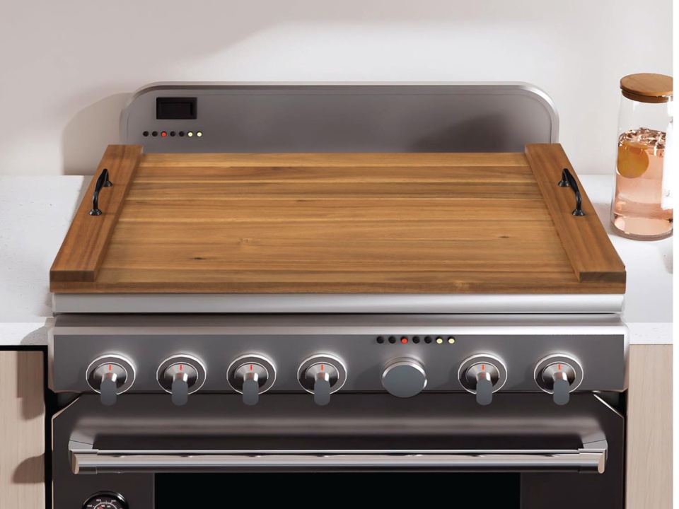 Wooden stove cover with black handles on each side, set on a kitchen range