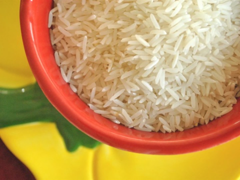 Long white rice grains in a red bowl seen from above