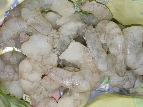 Tôm lột vỏ xếp chồng trên túi nhựa xanh
