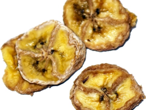 Three golden brown dried banana slices on a white background